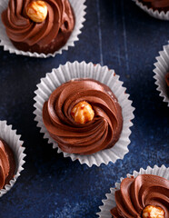 Meringue, pavlova chocolate cupcakes with cream and nuts