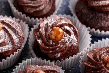 Meringue, pavlova chocolate cupcakes with cream, nuts and powder sugar