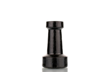 One old wooden chess piece in black, macro, isolated on a white background.