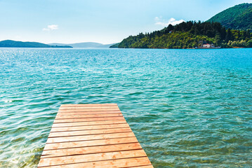 Beautiful scenic landscape with a boat in the bay and a wooden pier near Nydri, Lefkada, Greece. Stunning amazing charming places. prominent tourist towns.