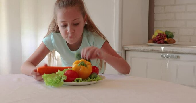 little girl in the kitchen. the child loves vegetables. healthy food concept. vitamins for a child