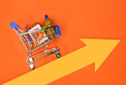 Shopping cart with groceries over an arrow