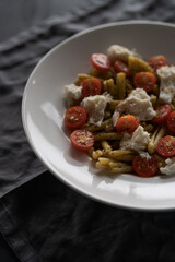 casarecce pasta with pesto, fresh cherry tomatoes and mozzarella