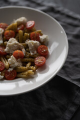 casarecce pasta with pesto, fresh cherry tomatoes and mozzarella
