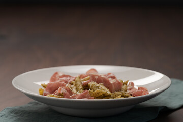 Penne pasta with capocollo, pesto and parmesan cheese