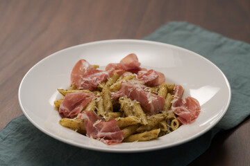 Penne pasta with capocollo, pesto and parmesan cheese