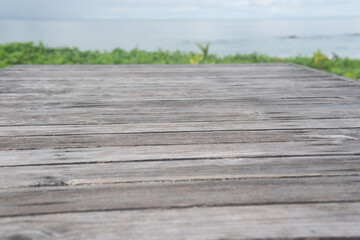 Fototapeta premium Panoramic empty clean wood counter table top blur shinny white bokeh light on summer beach background for product morning scene display montage, Abstract Blurry wooden desk in vacation trip backdrop.