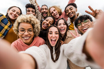 Multiracial friends taking big group selfie shot smiling at camera - Laughing young people standing outdoor and having fun - Cheerful students portrait outside school - Human resources concept - 485378187