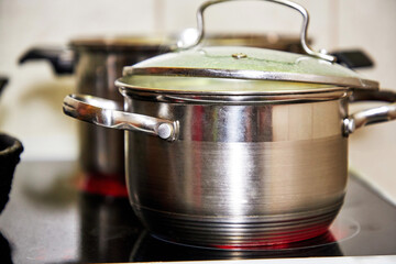 Lunch or dinner is cooked on the stove in a frying pan and pots