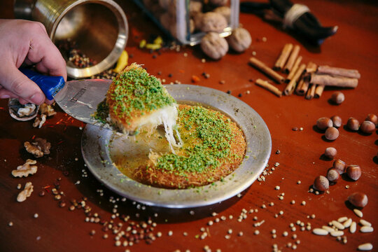 Turkish dessert kunefe, kunafa, kadayif with pistachio powder and cheese hot eaten a sweet