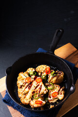 Food concept Roasted organic Cauliflower in skillet iron pan on black slate stone back ground with copy space