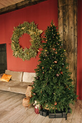 Stylish interior of the living room with a Christmas tree on a red background