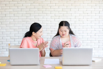 down syndrome teenage girl and her teacher using laptop computer for education
