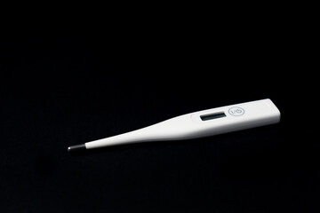 White digital thermometer on black background