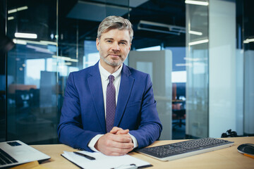 Portrait of successful seo boss, businessman at work, working on computer in modern office, looking at camera, happy and smiling