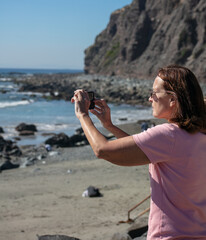 A Beautiful Mature Woman Using her Cell Phone to Take Pictures of the Ocean at Dana Point,...