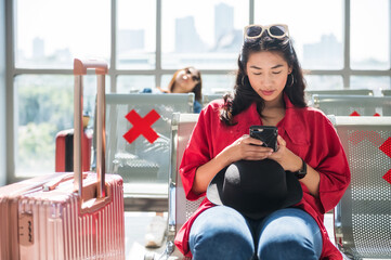 Asian woman using phone, wait to departure