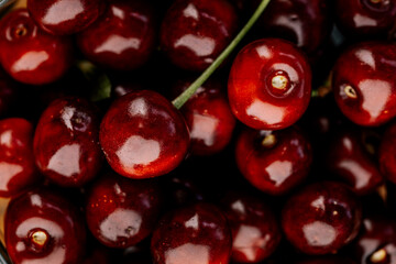 Ripe cherry with stems and leaves. A large collection of fresh red cherries. Ripe cherries background