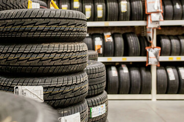 Car tires and wheels at warehouse in tire store. - obrazy, fototapety, plakaty
