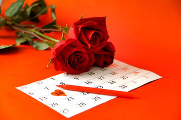 Three red roses and a calendar with the date.