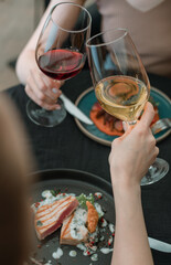 Celebration, two women with glasses of red and white wine in a restaurant on a holiday.