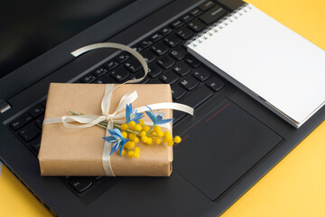 gift box decorated with spring flowers, notebook on yellow background. gift for 8 march, congratulations on mother's day