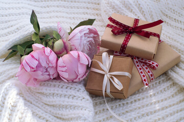 three gift boxes, a bouquet of beautiful peonies on a light background. congratulations on Valentine's Day, mother's day, birthday. romantic background