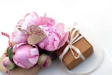 gift box wooden heart, a bouquet of beautiful pink peonies on a white background. congratulations on Valentine's Day, mother's day, birthday. romantic background.