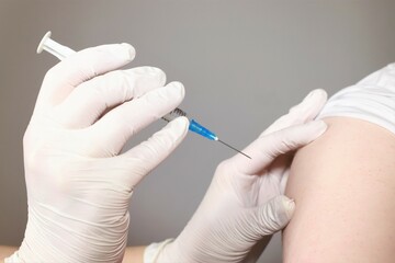 Hands in white rubber gloves prepared to do an injection into shoulder