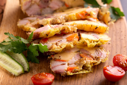 Homemade salceson with meat and cheese on wooden board