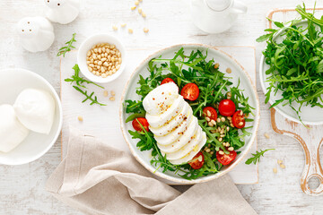 Salad with arugula, mozzarella cheese and pine nuts. Breakfast. Ketogenic, keto or paleo diet. Healthy food. Top view