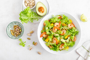 Grilled shrimp salad with avocado, mango, lettuce and pistachios, dressed with lime. Healthy food. Ketogenic diet. Top view.