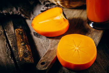 A group of ripe orange persimmon fruits.Persimmon fruits on a wooden board, rustic background