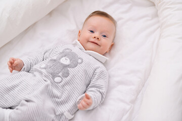 Newborn baby lying on a bed sleeping on white sheets. Newborn child relaxing in bed. Nursery for young children. Lifestyle concept.