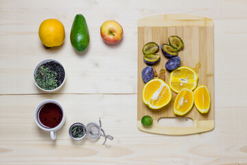 Naklejka na ściany i meble Fruits. Bright healthy food on a bright table. Avocados, figs, plums, apples, oranges. Tea. Flatley