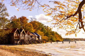 Boat houses at Ammersee in Bavaria with autumn coloured trees