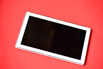 Tablet on red background, business and education tool on color background, space for your text
