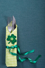 Silverware in green napkin for St Patrick day on table