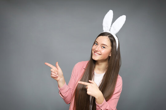 Attractive woman in bunny ears costume Picture taken on grey background with copy space