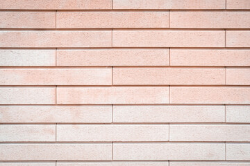 Pink and peachy brick wall texture background. Pastel tones. Beautiful, stylish, tender backdrop. Bright stone structure covered with stucco and paint. Construction material. Close up, copy space