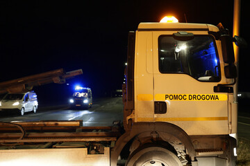 Samochód pomocy drogowej podczas obsługi wypadku drogowego w nocy na drodze.  - obrazy, fototapety, plakaty