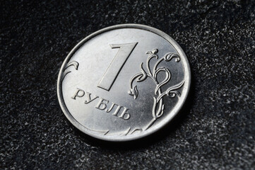 a Russian one ruble coin lies on a dark metal background. close-up