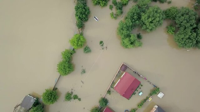 GALYCH, UKRAINE - JUNE 24, 2020: Flooded neighborhood street. Major flooding leaves city, underwater, entire community. Homes, houses overflowing water, insurance needed. Rescue teams helping people