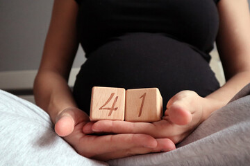 Pregnant woman holding cubes with 41 weeks gestation