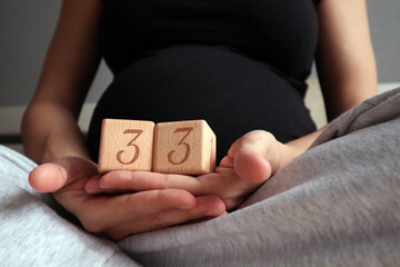 Pregnant woman holding cubes with 33 weeks gestation