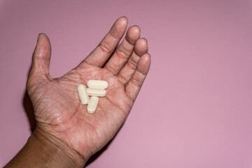 Close up picture of a man hand holding Vitamin C pills, 1000mg.