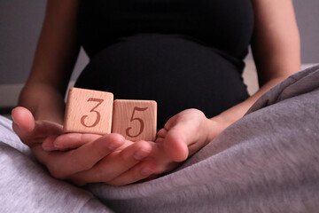 Pregnant woman holding cubes with 35 weeks gestation