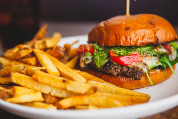 Cheeseburger with pesto sauce and a side of french fries