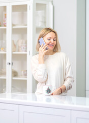 Fototapeta premium Young beautiful blonde girl at home in the kitchen