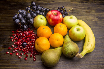 Ripe grapes, apples, bananas, tangerines, pears, pomegranate seeds.